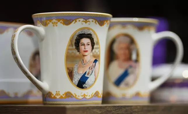 Mugs with photos of late Queen Elizabeth II are on display for sale at a souvenirs shop in London, on April 17, 2026. (AP Photo/Kin Cheung)