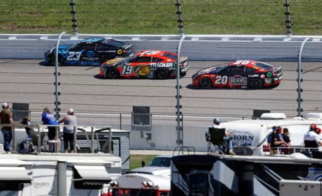 Bubba Wallace (23) Chase Briscoe (19) and Christopher Bell (20) head into Turn 3 during a NASCAR Cup Series auto race at Kansas Speedway in Kansas City, Kan., Sunday, April 19, 2026. (AP Photo/Colin E. Braley)