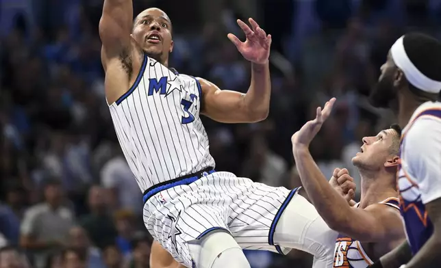 Orlando Magic guard Desmond Bane (3) scores a basket as Phoenix Suns guard Grayson Allen, second from right, and forward Royce O'Neale, right, look on during the second half of an NBA basketball game, Tuesday, March 31, 2026, in Orlando, Fla. (AP Photo/Phelan M. Ebenhack)