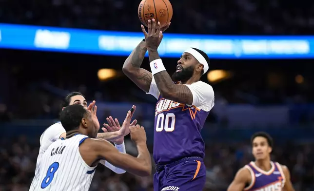 Phoenix Suns forward Royce O'Neale (00) goes up to shoot as Orlando Magic forward Jamal Cain (8) defends during the first half of an NBA basketball game, Tuesday, March 31, 2026, in Orlando, Fla. (AP Photo/Phelan M. Ebenhack)