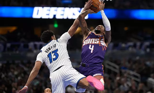 Phoenix Suns guard Jalen Green (4) goes up to shoot as Orlando Magic guard Jett Howard (13) defends during the first half of an NBA basketball game, Tuesday, March 31, 2026, in Orlando, Fla. (AP Photo/Phelan M. Ebenhack)