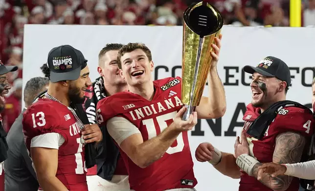 FILE - Indiana quarterback Fernando Mendoza holds the trophy after Indiana defeated Miami in a College Football Playoff national championship game in Miami Gardens, Fla., Jan. 19, 2026, (AP Photo/Lynne Sladky, File)