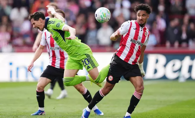 Fulham's Sasa Lukic, left, and Brentford's Kevin Schade battle for the ball during the English Premier League soccer match between Brentford and Fulham in Brentford, England, Saturday April 18, 2026. (John Walton/PA via AP)