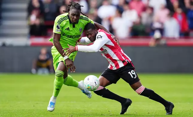 Fulham's Calvin Bassey, left, and Brentford's Dango Ouattara battle for the ball during the English Premier League soccer match between Brentford and Fulham in Brentford, England, Saturday April 18, 2026. (John Walton/PA via AP)