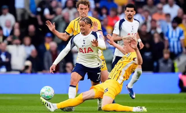 Tottenham Hotspur's Xavi Simons, left, and Brighton and Hove Albion's Jan Paul van Hecke battle for the ball during their English Premier League soccer match in London, Saturday, April 18, 2026. (Jordan Pettitt/PA via AP)