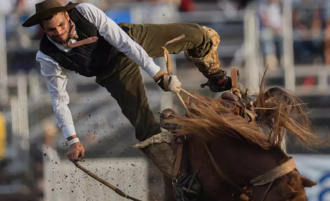 FILE - A "gaucho," or cowboy, rides a horse during the Criolla Week rodeo festival, an annual festival held during Holy Week, in Montevideo, Uruguay, April 2, 2026. (AP Photo/Matilde Campodonico, File)