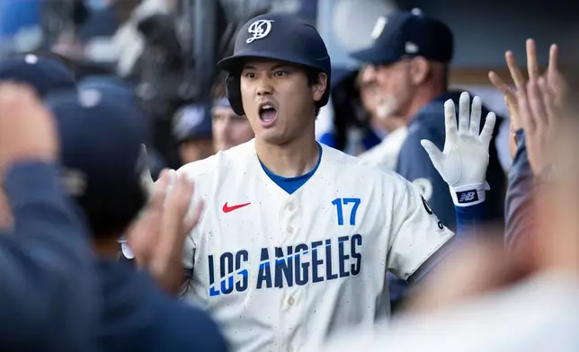Los Angeles Dodgers' Shohei Ohtani celebrates his solo home run with the bench during the first inning of a baseball game against the Texas Rangers in Los Angeles, Saturday, April 11, 2026. (AP Photo/Kyusung Gong)
