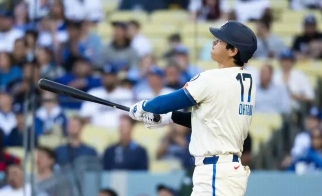 Los Angeles Dodgers' Shohei Ohtani watches his solo home run during the first inning of a baseball game against the Texas Rangers in Los Angeles, Saturday, April 11, 2026. (AP Photo/Kyusung Gong)