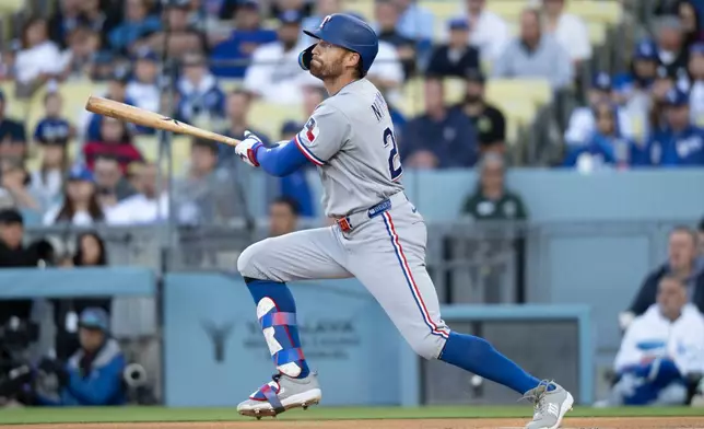 Texas Rangers' Brandon Nimmo watches his solo home run during the first inning of a baseball game against the Los Angeles Dodgers in Los Angeles, Saturday, April 11, 2026. (AP Photo/Kyusung Gong)