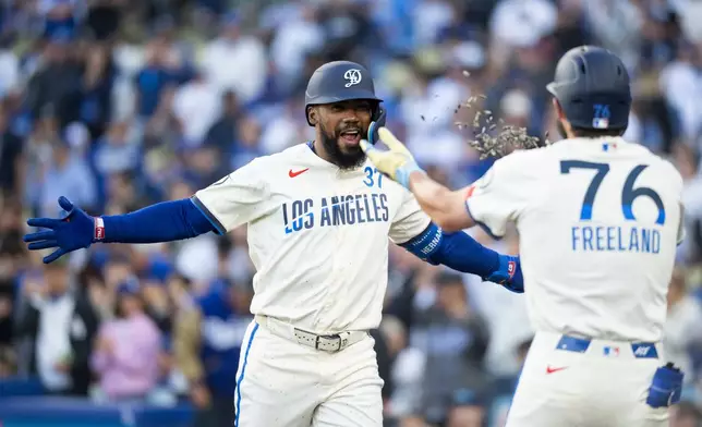 Los Angeles Dodgers' Teoscar Hernández, left, celebrates his three-run home run with Alex Freeland during the first inning of a baseball game against the Texas Rangers in Los Angeles, Saturday, April 11, 2026. (AP Photo/Kyusung Gong)