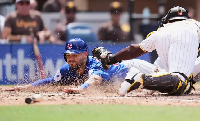 Chicago Cubs' Michael Conforto, left, slides in to score off an RBI groundout by Pete Crow-Armstrong as San Diego Padres catcher Luis Campusano is late with the tag during the sixth inning of a baseball game Wednesday, April 29, 2026, in San Diego. (AP Photo/Gregory Bull)