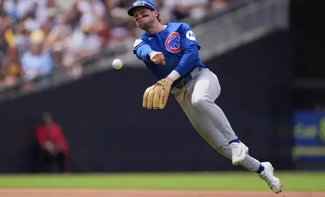 Chicago Cubs shortstop Nico Hoerner throws to first too late as San Diego Padres' Fernando Tatis Jr. arrives safely with a single during the sixth inning of a baseball game Wednesday, April 29, 2026, in San Diego. (AP Photo/Gregory Bull)