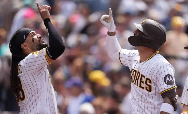 San Diego Padres' Nick Castellanos, right, celebrates with teammate Fernando Tatis Jr. after hitting a two-run home run during the fifth inning of a baseball game against the Chicago Cubs Wednesday, April 29, 2026, in San Diego. (AP Photo/Gregory Bull)