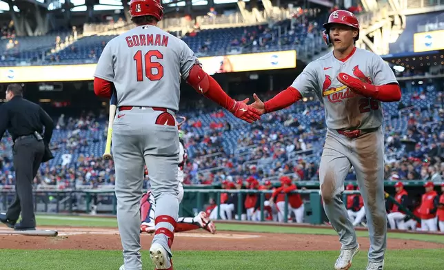 St. Louis Cardinals' JJ Wetherholt celebrates with St. Louis Cardinals' Nolan Gorman after scoring a run during the first inning of a baseball game against the Washington Nationals, Tuesday, April 7, 2026, in Washington. (AP Photo/Daniel Kucin Jr.)