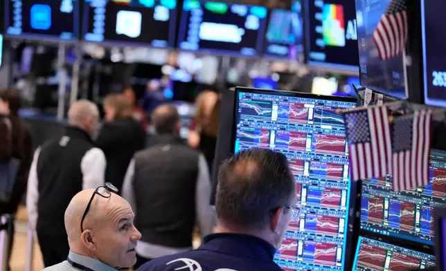 People work on the floor at the New York Stock Exchange in New York, Tuesday, March 31, 2026. (AP Photo/Seth Wenig)