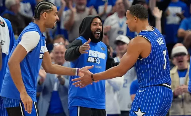 Orlando Magic guard Desmond Bane, right, celebrates with teammates guard Jett Howard, left, and guard Jase Richardson, center, during the second half in Game 4 of a first-round NBA basketball playoff series, Monday, April 27, 2026, in Orlando, Fla. (AP Photo/John Raoux)