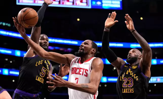Houston Rockets forward Kevin Durant, center, shoots as Los Angeles Lakers center Deandre Ayton, left, and forward LeBron James defend during the first half in Game 2 of a first-round NBA playoffs basketball series Tuesday, April 21, 2026, in Los Angeles. (AP Photo/Mark J. Terrill)
