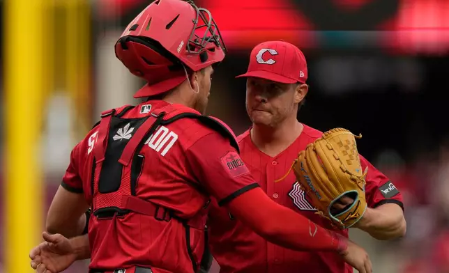 Cincinnati Reds pitcher Emilio Pagán, right, and Cincinnati Reds catcher Tyler Stephenson, left, embrace after winning a baseball game against the Los Angeles Angels in Cincinnati, Saturday, April 11, 2026. (AP Photo/Carolyn Kaster)