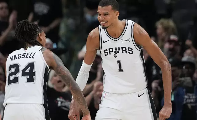 San Antonio Spurs forward/center Victor Wembanyama (1) reacts with guard/forward Devin Vassell (24) after a play during the second half in Game 5 of a first-round NBA playoffs basketball series in San Antonio, Tuesday, April 28, 2026. (AP Photo/Eric Gay)