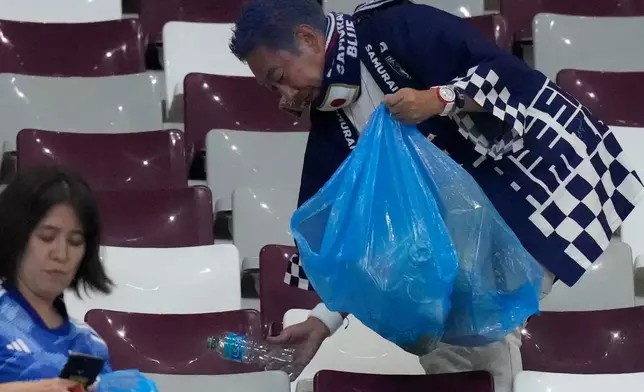 FILE - Japan supporters clean the stands at the end of the World Cup group E soccer match between Germany and Japan, at the Khalifa International Stadium in Doha, Qatar, on Nov. 23, 2022. (AP Photo/Eugene Hoshiko, File)
