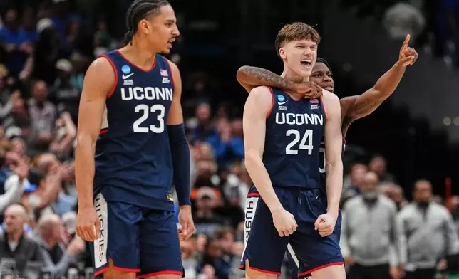 UConn guard Braylon Mullins (24) reacts with teammates after scoring the winning basket against Duke in the Elite Eight of the NCAA college basketball tournament, Sunday, March 29, 2026, in Washington. (AP Photo/Abbie Parr)