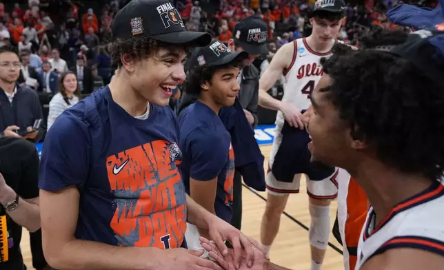 Illinois' Keaton Wagler, left, celebrates with a teammate after Illinois beat Iowa in an Elite Eight game in the NCAA college basketball tournament Saturday, March 28, 2026, in Houston. (AP Photo/Eric Gay)