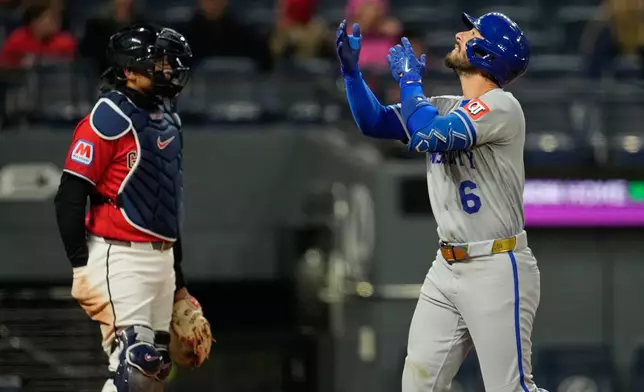 Kansas City Royals' Jonathan India gestures in front of Cleveland Guardians catcher Bo Naylor, left, as he crosses the plate with a two-run home run in the eighth inning of a baseball game against the Cleveland Guardians in Cleveland, Monday, April 6, 2026. (AP Photo/Sue Ogrocki)