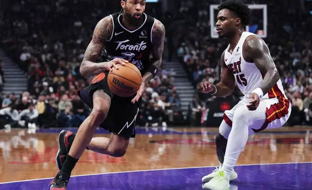Toronto Raptors' Brandon Ingram (3) drives around Miami Heat's Davion Mitchell (45) during the first half of an NBA basketball game in Toronto, Thursday, April 9, 2026. (Nathan Denette/The Canadian Press via AP)