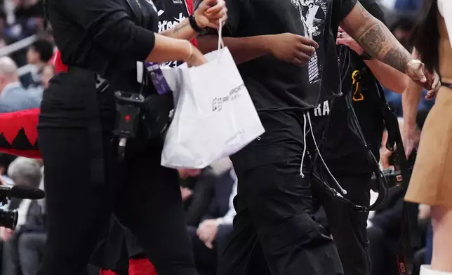 Toronto Blue Jays' Vladimir Guerrero Jr., right, makes an appearance during first-half NBA basketball game action between the Toronto Raptors and the Miami Heat in Toronto, Ontario, Thursday, April 9, 2026. (Nathan Denette/The Canadian Press via AP)