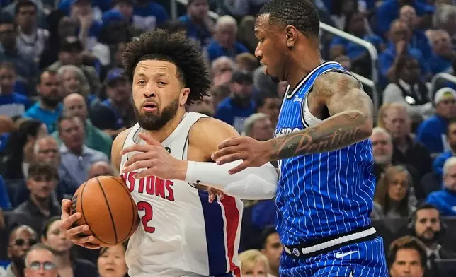 Detroit Pistons guard Cade Cunningham, left, moves past Orlando Magic forward Jamal Cain during the first half in Game 4 of a first-round NBA basketball playoff series, Monday, April 27, 2026, in Orlando, Fla. (AP Photo/John Raoux)
