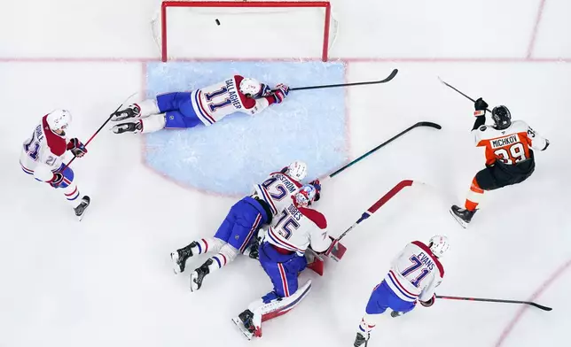 Philadelphia Flyers' Matvei Michkov (39) scores a goal past the defense of Montréal Canadiens' Brendan Gallagher (11), Kaiden Guhle (21), Adam Engstrom (42), Jake Evans (71) and goaltender Jakub Dobes (75) during the second period of an NHL hockey game, Tuesday, April 14, 2026, in Philadelphia. (AP Photo/Derik Hamilton)