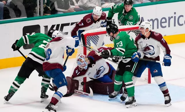 Colorado Avalanche goaltender Scott Wedgewood (41) reaches down to block a shot under pressure from Dallas Stars right wing Arttu Hyry, left, and Adam Erne (73) in the third period of an NHL hockey game Saturday, April 4, 2026, in Dallas. (AP Photo/Tony Gutierrez)