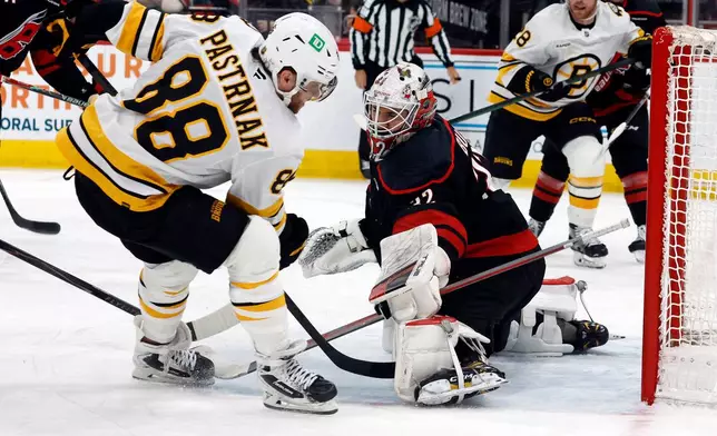 Boston Bruins' David Pastrnak (88) has his shot blocked by Carolina Hurricanes goaltender Brandon Bussi (32) during the third period of an NHL hockey game in Raleigh, N.C., Tuesday, April 7, 2026. (AP Photo/Karl DeBlaker)