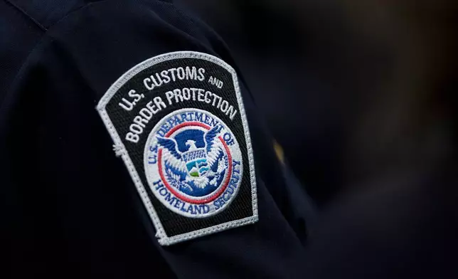 FILE - A customs agent wears a patch for the U.S. Customs and Border Protection agency, Oct. 27, 2017, at John F. Kennedy International Airport in New York. (AP Photo/Mark Lennihan, file)