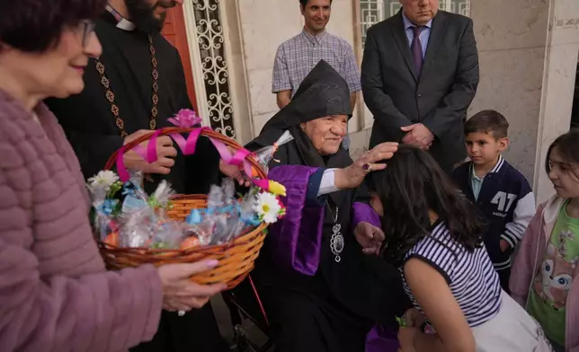 Sepuh Sargsyan, archbishop and prelate of the Armenian Apostolic Diocese of Tehran, blesses a child after Easter Sunday Mass at Saint Sarkis Cathedral in Tehran, Iran, Sunday, April 5, 2026. (AP Photo/Francisco Seco)