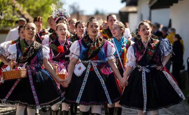 Young women in folk costumes sing during the Easter folk festival in the village of Holloko, a UNESCO World Heritage site, in northeastern Hungary, on Easter Sunday, April 5, 2026. (Peter Komka/MTI via AP)
