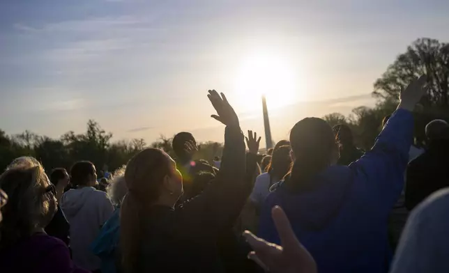 People raise their hands to the sky during an Easter Sunday sunrise prayer service at the Lincoln Memorial, Sunday, April 5, 2026, in Washington. (AP Photo/Rod Lamkey, Jr.)