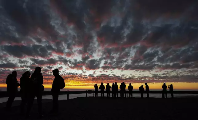 Astronomers are silhouetted against the sunset sky at Paranal Observatory in the Atacama Desert, Chile, Tuesday, April 14, 2026. (AP Photo/Esteban Felix)