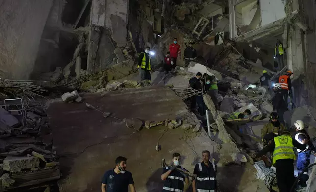 FILE - Rescuers gather at a destroyed building that was hit in an Israeli airstrike in central Beirut, Lebanon, April 8, 2026. (AP Photo/Emilio Morenatti, File)