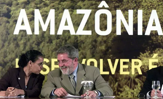 FILE - Brazil's President Luiz Inacio lula da Silva talks to Environment Minister Marina Silva, left, at a ceremony in Brasilia, Brazil on March 15, 2004. (AP Photo/Eraldo Peres, File)