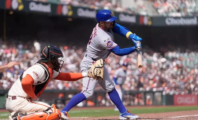 New York Mets' Luis Torrens, right, hits a two-run double next to San Francisco Giants catcher Patrick Bailey, left, during the eighth inning of a baseball game in San Francisco, Sunday, April 5, 2026. (AP Photo/Jeff Chiu)