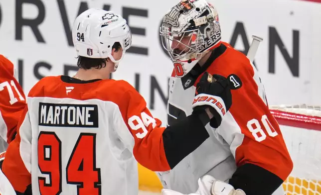Philadelphia Flyers goaltender Dan Vladar (80) celebrates with Porter Martone (94) after time ran out in Game 2 in the first round of the NHL Stanley Cup playoffs against the Pittsburgh Penguins in Pittsburgh, Monday, April 20, 2026. (AP Photo/Gene J. Puskar)