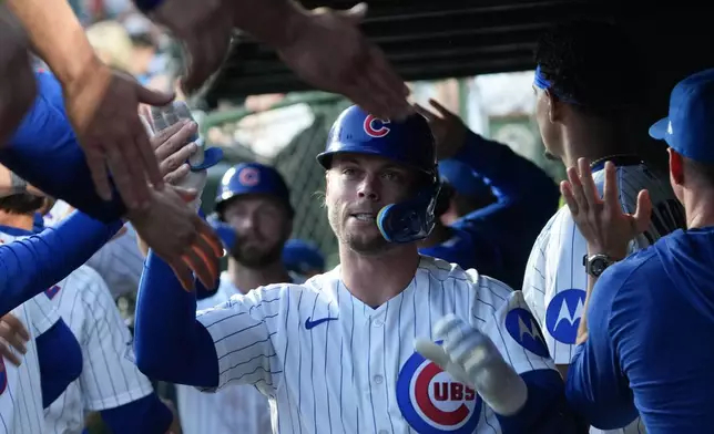Chicago Cubs' Nico Hoerner (2) is greeted in the dugout after driving in a run against the Los Angeles Angels during the first inning in a baseball game Monday, March 30, 2026, in Chicago. (AP Photo/David Banks)
