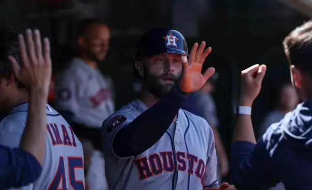 Houston Astros' Christian Walker, center, celebrates in the dugout after scoring during the sixth inning of a baseball game against the Athletics, Saturday, April 4, 2026, in West Sacramento, Calif. (AP Photo/Sara Nevis)