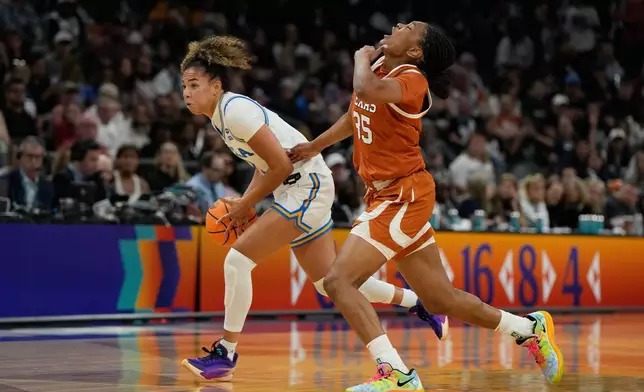 UCLA guard Kiki Rice (1) drives against Texas forward Madison Booker (35) during the first half of a woman's NCAA college basketball tournament semifinal game at the Final Four, Friday, April 3, 2026, in Phoenix. (AP Photo/Ross D. Franklin)