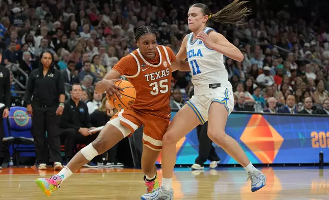 Texas forward Madison Booker (35) drives against UCLA guard Gabriela Jaquez (11) during the first half of a women's NCAA college basketball tournament semifinal game at the Final Four, Friday, April 3, 2026, in Phoenix. (AP Photo/Rick Scuteri)