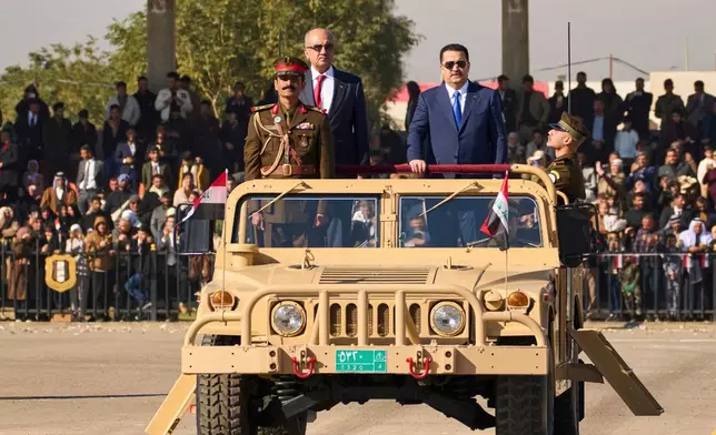 FILE - Iraqi Prime Minister Mohammed Shia al-Sudani, right, rides in a Humvee during the Army Day celebrations, in Baghdad, Iraq, Tuesday, Jan. 6, 2026. (AP Photo/Hadi Mizban, File)
