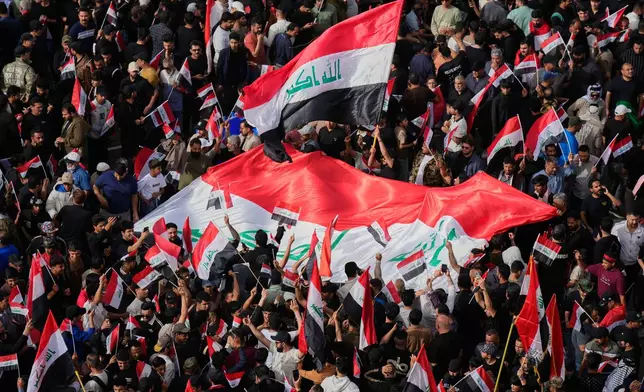 FILE - Followers of Iraq's Shiite cleric Muqtada al-Sadr chant slogans as they wave national Iraqi flag during a protest against U.S. and Israeli attacks on multiple cities across Iran, in Tahrir Square, Baghdad, Iraq, Saturday, April 4, 2026. (AP Photo/Hadi Mizban, File)