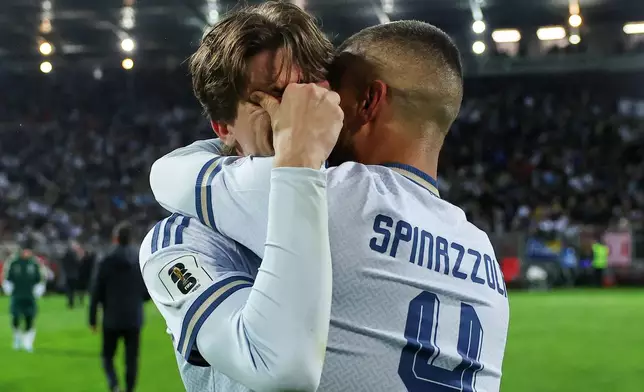 Italy's Marco Palestra, left, and Leonardo Spinazzola console each other after losing a penalty shootout during the World Cup qualifying playoff final soccer match between Bosnia and Italy in Zenica, Bosnia, Tuesday, March 31, 2026. (AP Photo/Armin Durgut)