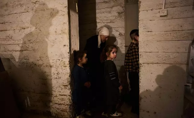 People take cover in a bomb shelter as air raid sirens warn of incoming Iranian missile strikes in Bnei Brak, Israel, Wednesday, April 1, 2026. (AP Photo/Oded Balilty)